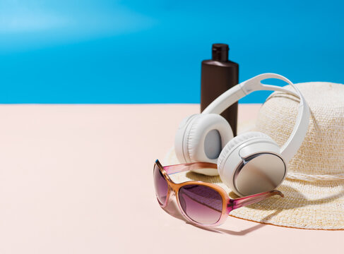 Summer Travel Essentials with Headphones Sunscreen Hat and Sunglasses