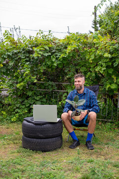 Man Working Outdoors with Laptop and Potted Plant