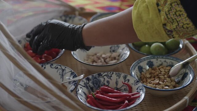 Bowls of chili peanuts limes and tomatoes on a bamboo tray