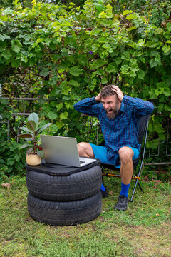 Frustrated Bearded Man Reacting to Laptop in Backyard