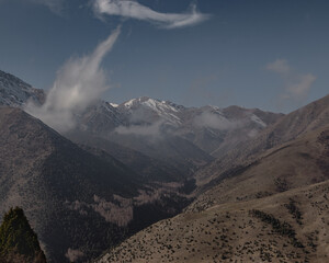 Clouds drifting across snow-dusted mountains in Ala-Archa National Park, Kyrgyzstan © Shadowww