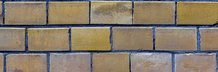 Old brick wall with yellow and brown textured bricks and dark mortar background © Harry