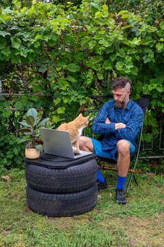 Man and Cat Working Outside at Makeshift Tire Desk