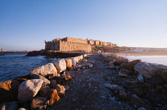 Stone fortress along a coastal path with scenic ocean views, emphasizing heritage and tranquility.
