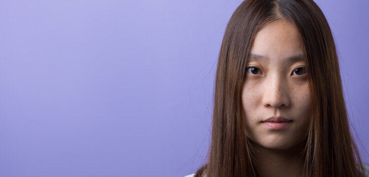 Young Chinese Woman Portrait with Copy Space on Purple Background