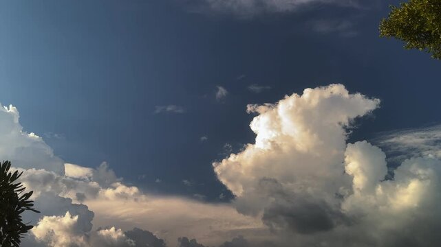 Blue sky with white clouds and the sun. Fast-moving white and gray clouds. Time-lapse photograph of cumulus clouds. Nature time-lapse video in the rainy season. Weather. Sky. Nature.