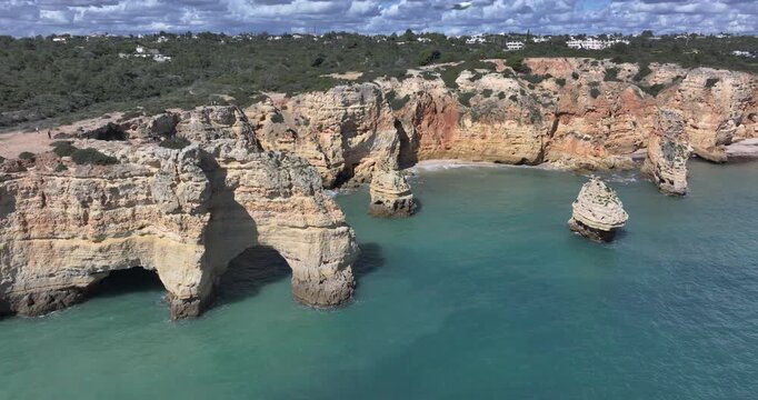 Aerial pass along Praia da Marinha sea arches and cliffs in Algarve