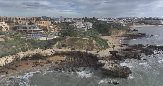 Rocky Albufeira coastline with resort hotels on a cloudy morning