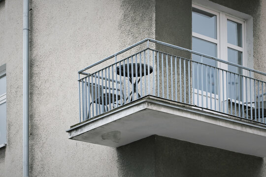 Balkon eines &auml;lteren grauen Wohnhauses mit Tisch und Stuhl in der Innenstadt von Danzig, Gdansk in Polen 
