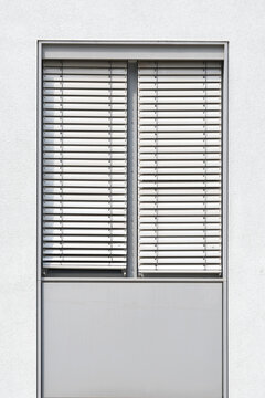 Fenster mit verschlossener Jalousie als Sonnenschutz an einem B&uuml;rogeb&auml;ude