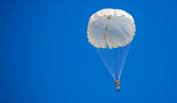 Skydiving. Flying parachutists against the background of the blue sky and mountains. Extreme sport and entertainment.