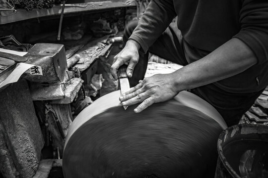 Man sharpening the knife with traditional stone wheel sharperner on the market in old Medina in Fes, Morocco
