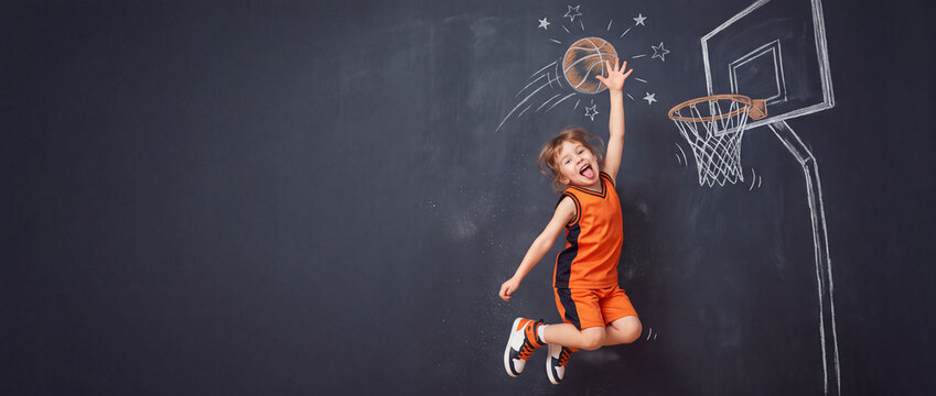 Happy child playing basketball with drawn hoop on a chalkboard background