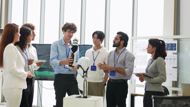 Curly-haired engineer presents a bionic robotic arm to a diverse team of colleagues in a bright glass office, during a prototype review, a tech startup innovation concept