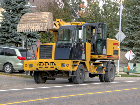 Calgary, Alberta, Canada. September 27, 2026. Yellow Gradall excavator parked on a suburban street during daylight.