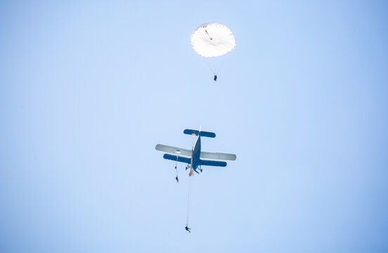 Skydiving. Parachutists jump from a flying plane in the air. Extreme sport and entertainment.