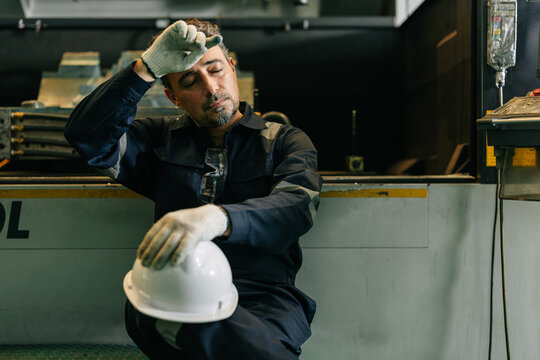 Engineer worker hot sweating tired resting relax brake in factory after industrial production work