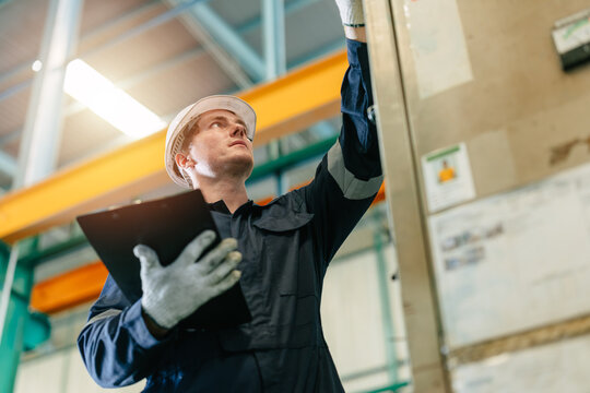 Professional factory engineer male inspecting control operate machine in industrial factory skillful