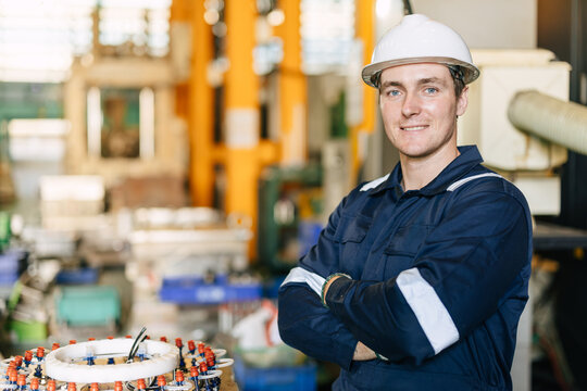Portrait Arm folded Happy Smiling Factory engineer worker in modern manufacturing plant