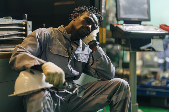 African Black male worker nap sleep tired factory resting after industrial production hard work