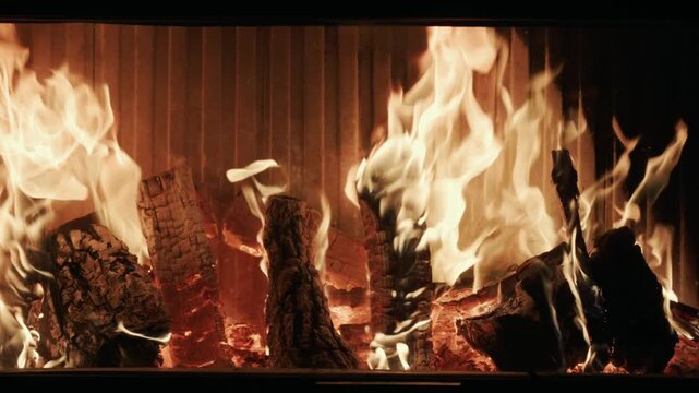 Warm glowing logs burn brightly in fireplace a cozy ambient background for winter holidays.