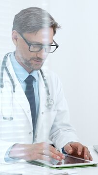 Male doctor in a white coat and stethoscope using a tablet computer for medical consultation. Electronic health records. And telemedicine