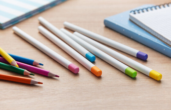 Colorful pencils and school supplies on wooden table