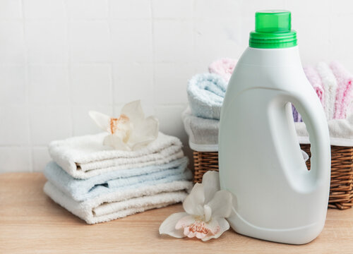 Laundry detergent bottle with fresh clean towels and orchids