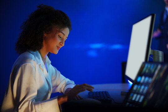 Professional woman working at a computer in a data monitoring office. Digital analytics support business performance, market research and strategic decision making.