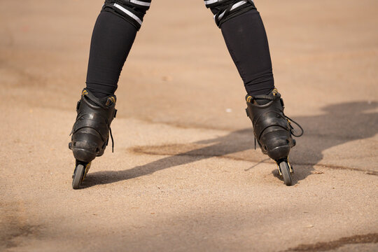 Person inline skating outdoors on asphalt surface
