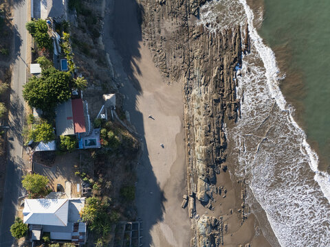 Rocky stone beach with houses above top view