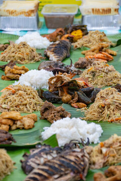 Traditional Filipino boodle fight feast served on banana leaves with rice, pancit noodles, grilled fish, seafood, meat, and assorted shared dishes.