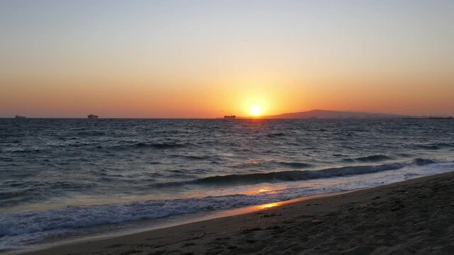 View from Sunset Beach in Huntington Beach, California. Long Beach industry and oil platforms, waves of the Pacific Ocean surf. September, 2026.