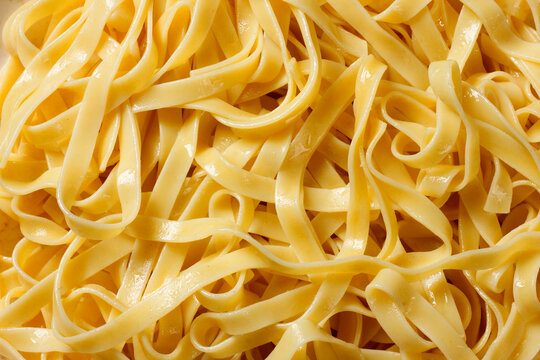 Close up of cooked fresh fettuccine, showing the soft texture and natural sheen of the Italian pasta.