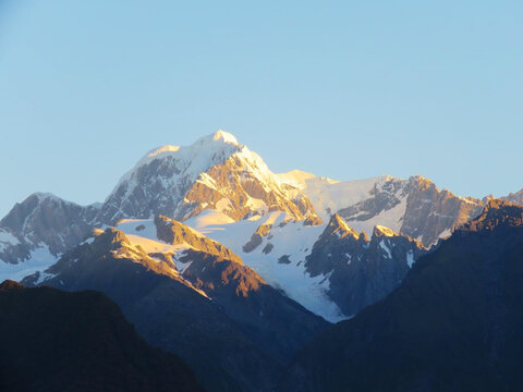 Majestic Mount Tasman Horokoau glowing in golden sunrise light above the Southern Alps, New Zealand