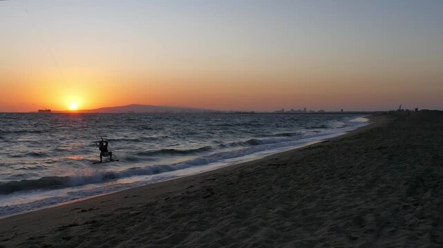 View from Sunset Beach in Huntington Beach, California. Long Beach industry and oil platforms, kite surfer riding waves of the Pacific Ocean surf. September, 2026.