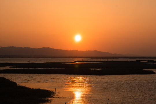 Scenic Sunset Over Calm Lake and Mountains