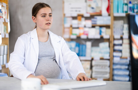 Pregnant woman pharmacist searches for information about medicines on the Internet using computer