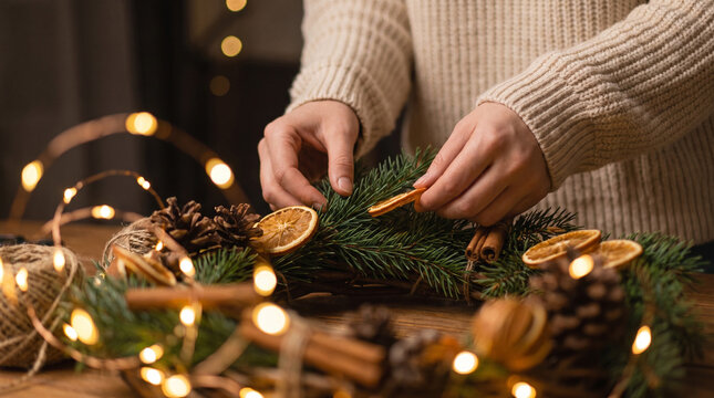 person making a handmade christmas wreath with dried fruit