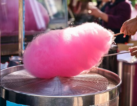 pink cotton candy being made at a fair stall