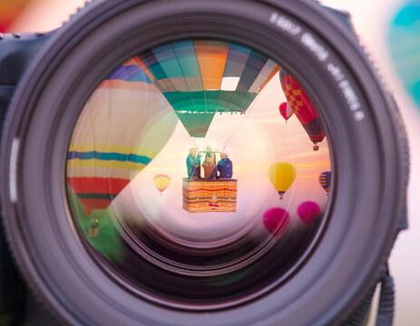 Hot air balloons reflected in a camera lens for travel photography concept