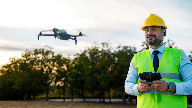 Drone pilot operates drone in an outdoor setting during the evening hours
