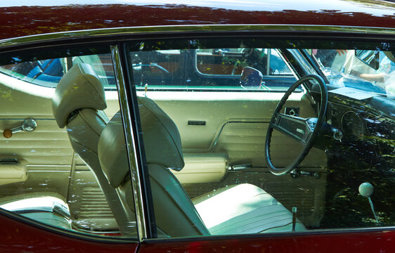 Legendary American 1969 Chevrolet Chevelle Malibu interior with green bench seats, classic steering wheel, cream door panels, and red exterior visible through window. Burgas, Bulgaria - July 04, 2026.