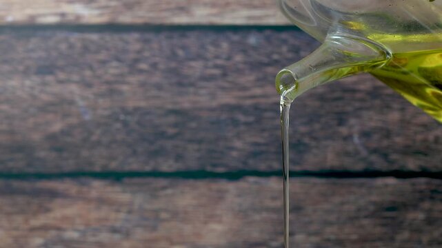 organic olive oil pouring from a glass bottle