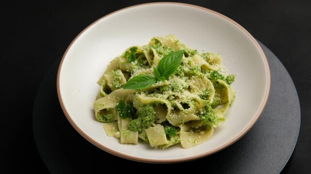 Vegetarian vegan green pasta, pappardelle pasta with broccoli pesto sauce and cheese in white plate.Healthy food.