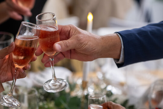 Two people seen clanking glasses in celebration