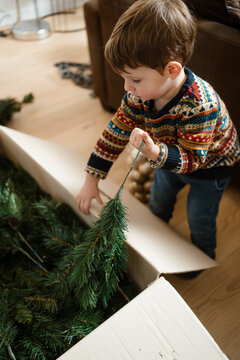 A toddler makes the Christmas tree at home