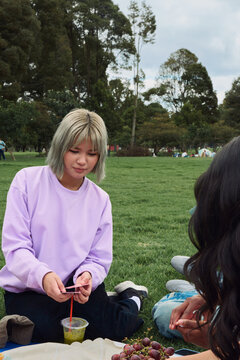 Friends playing card game during picnic in park