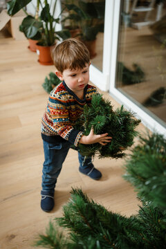 A toddler makes the Christmas tree at home