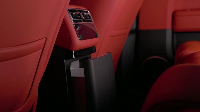 car interior with red seats and black seat belts in a neutral setting viewed from a fixed perspective showing leather or synthetic fabric seats and plastic seatbelts.